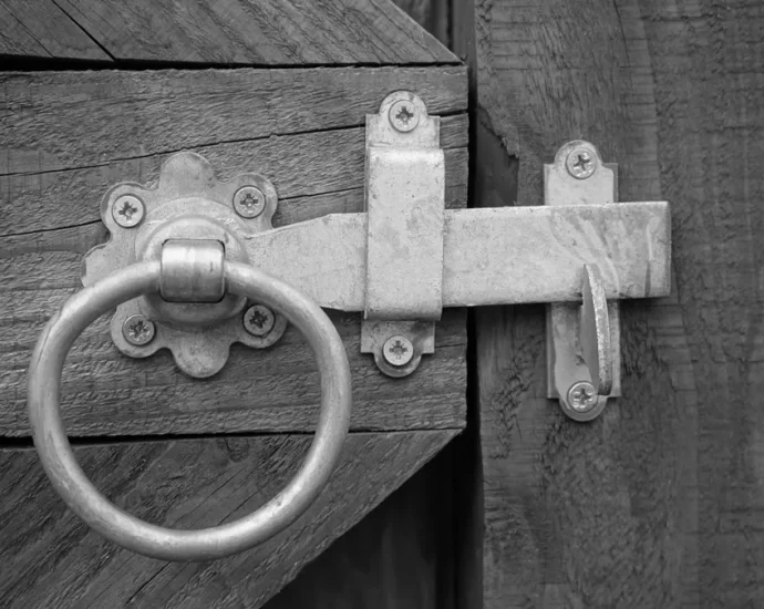 Metal ranch gate latch with ring handle on a wooden gate
